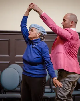A photo of an older woman and a younger man dancing.