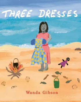 The book cover of Three Dresses by Wanda Gibson. It is an illustrated image of a woman standing on the beach holding a dress. There is a camp fire, doll and fish surrounding her on the sand.