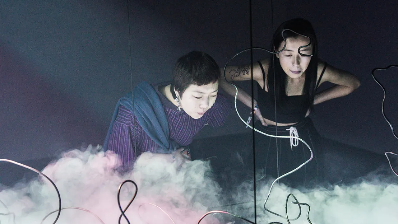 Two women looking at an art installation with dry ice