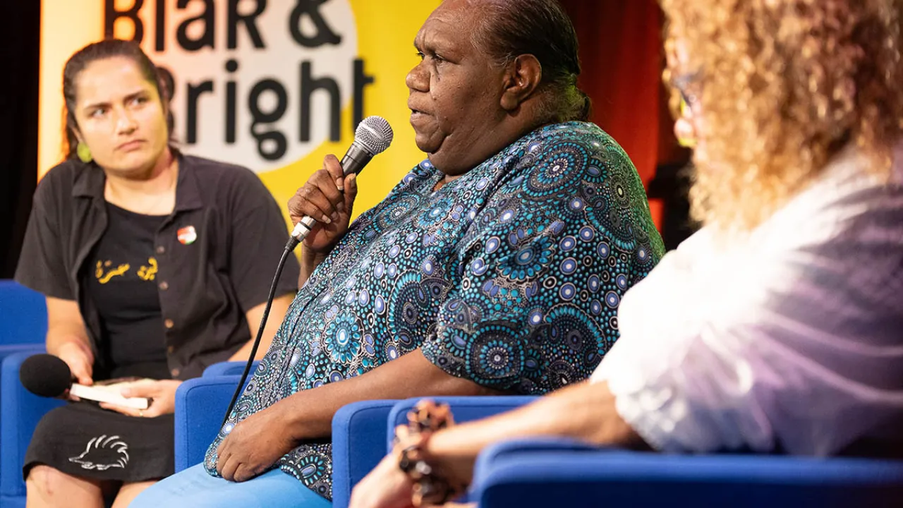 Three seated women speaking onstage at Blak & Bright 2024