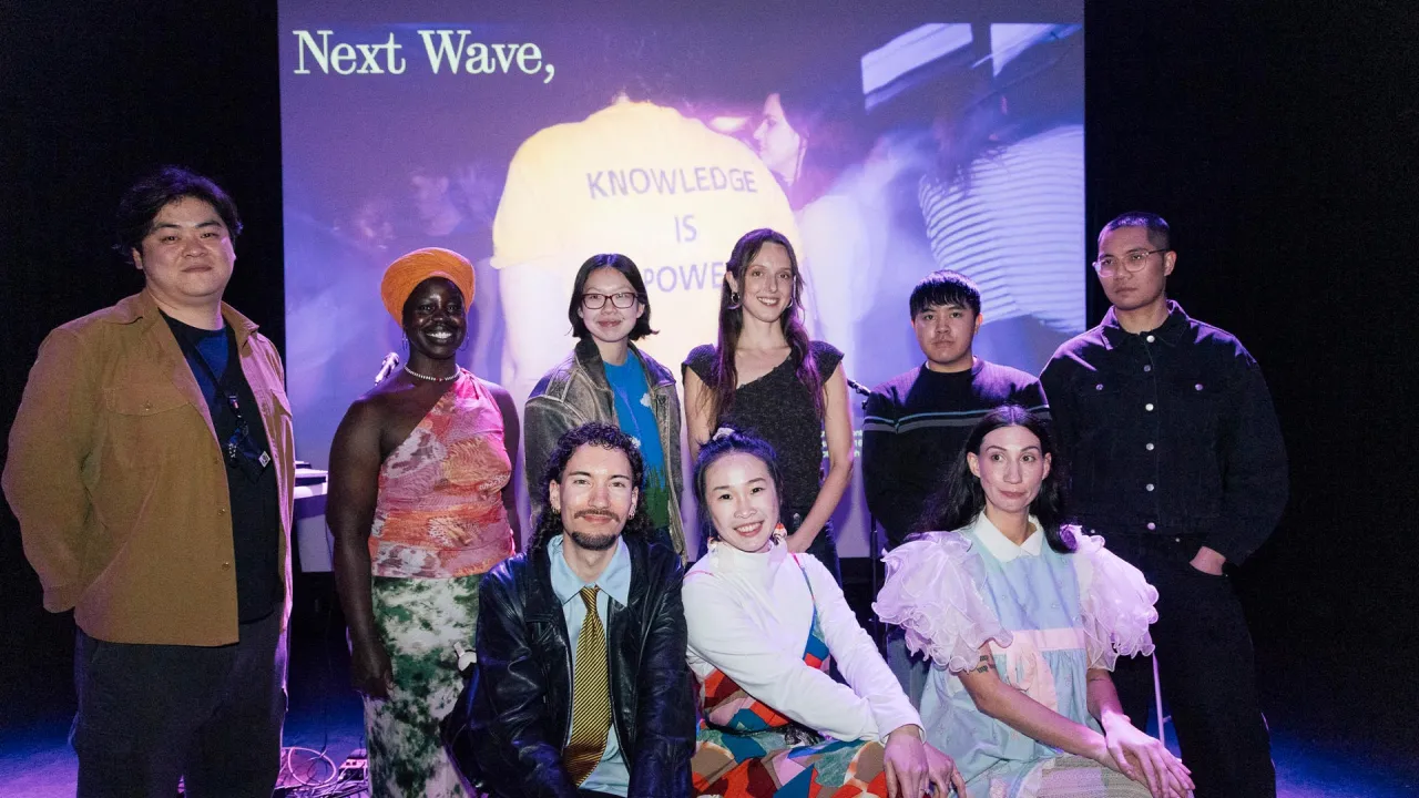 This is a photo of nine artists who are being supported through Next Wave's Kickstart program. They are a diverse group of younger people, standing shoulder to shoulder, smiling.