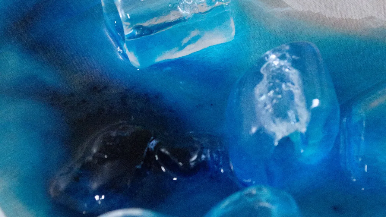 Ice melting over powdered dye, carrying vibrant turquoise and royal blue pigments through the silk to create blooming patterns. 