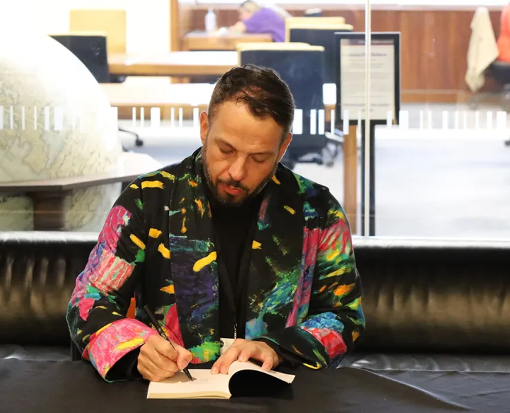 Scott-Patrick Mitchell signing copies of Clean at the 2023 PMLAs