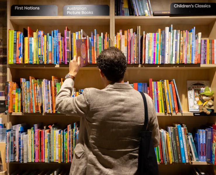 Photo of a person browsing a shelf full of books