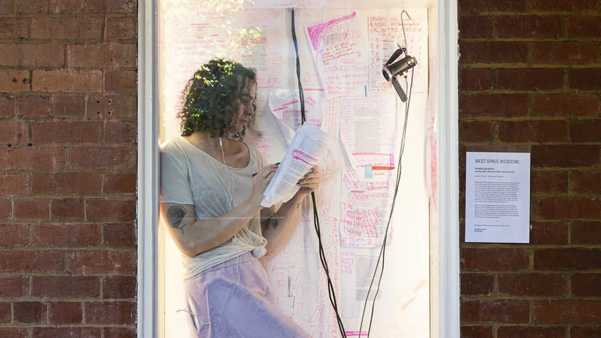 Woman in art installation in building's window.