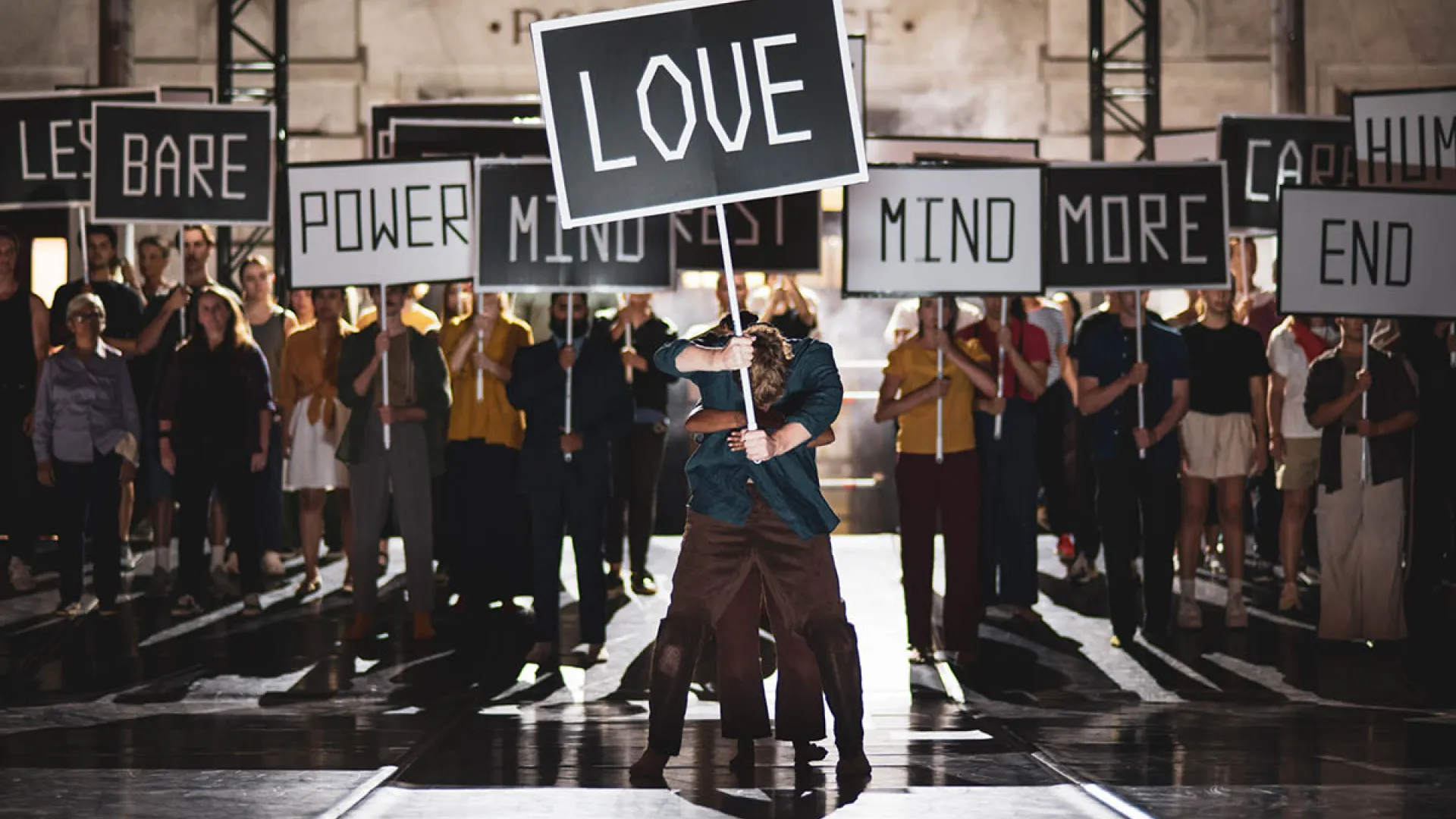 Performers holding signs onstage